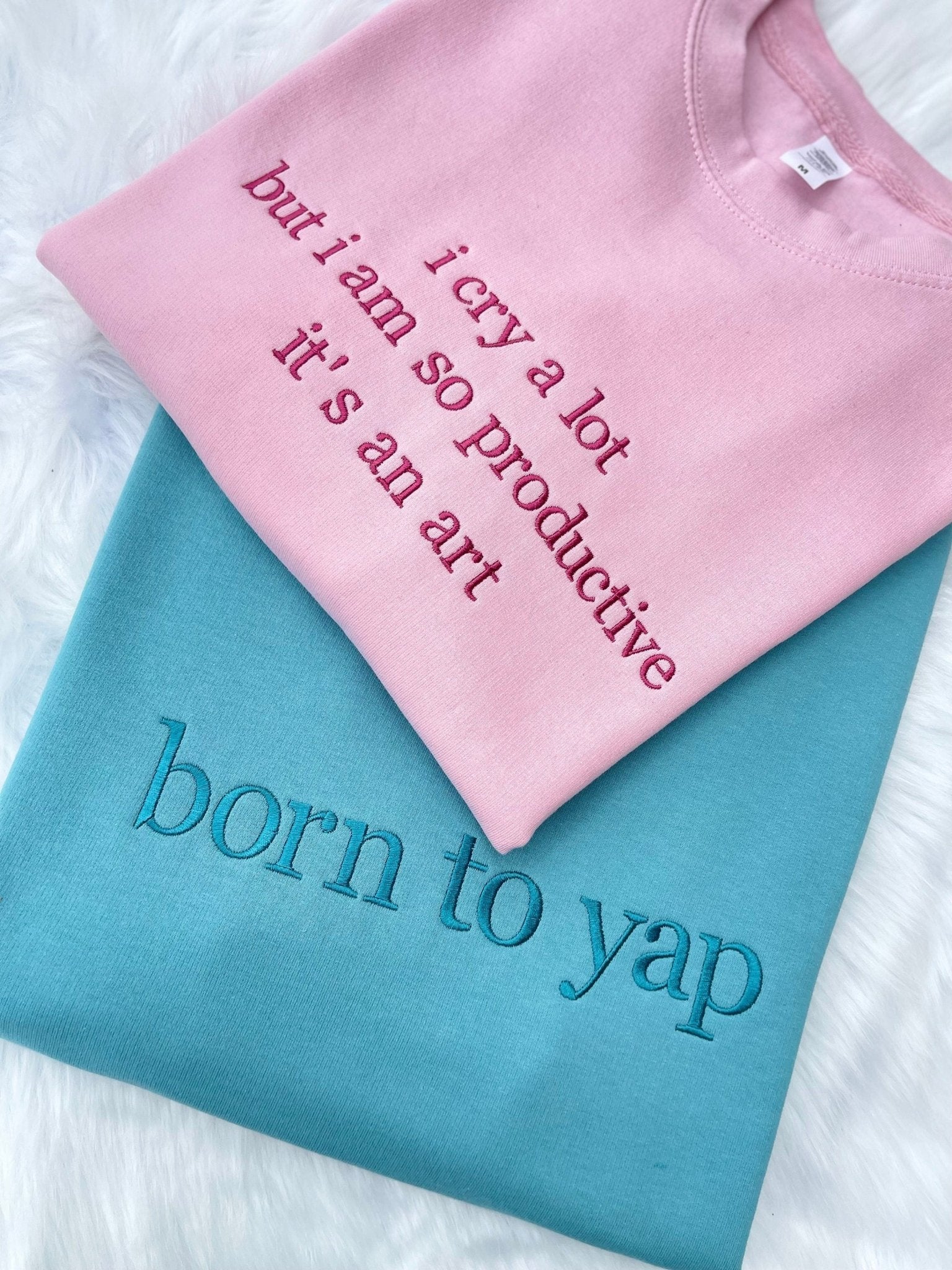 Pink and blue sweatshirts with custom slogan embroidery