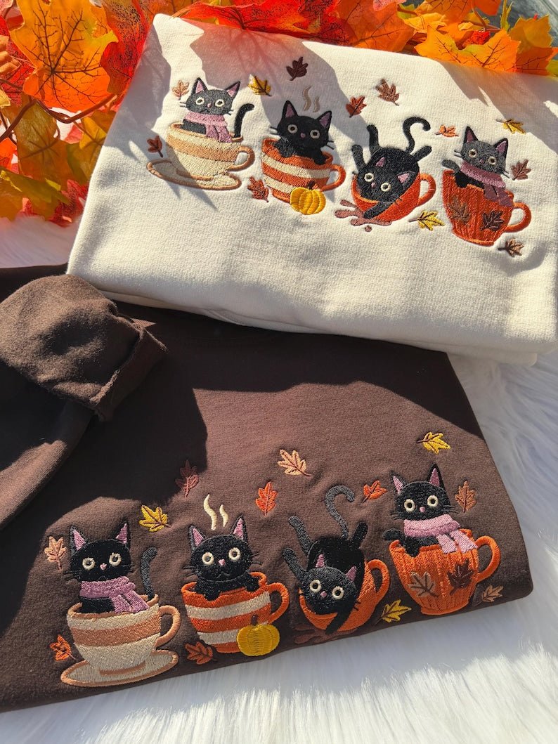 Cream and brown sweatshirt with embroidered black cats in autumn mugs with pumpkins and leaves