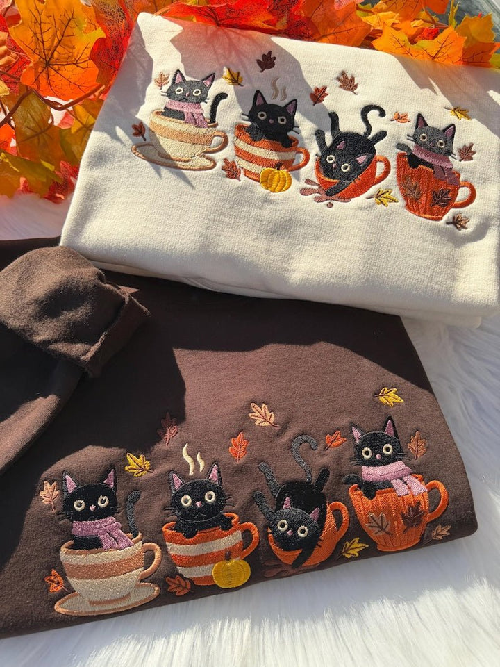 Cream and brown sweatshirt with embroidered black cats in autumn mugs with pumpkins and leaves