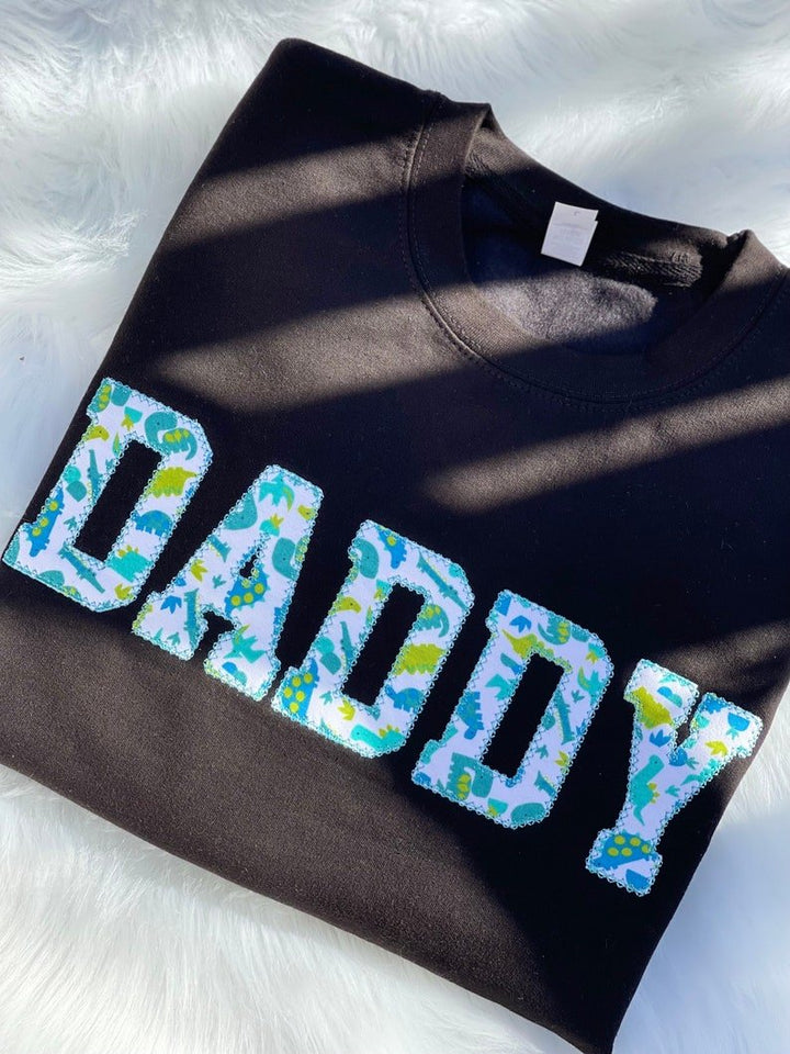 Blue sweatshirt with appliqué “Daddy” in blue patterned fabric letters