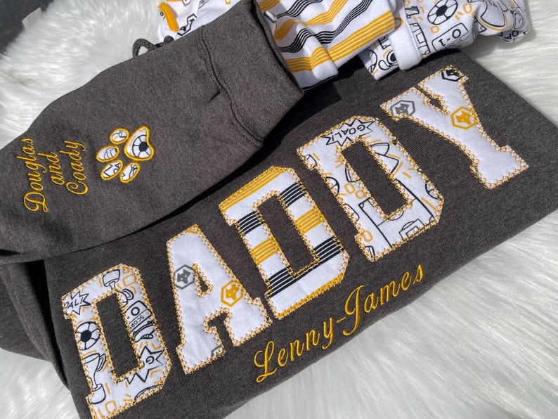 Grey sweatshirt with appliqué “Daddy” in gold patterned fabric letters