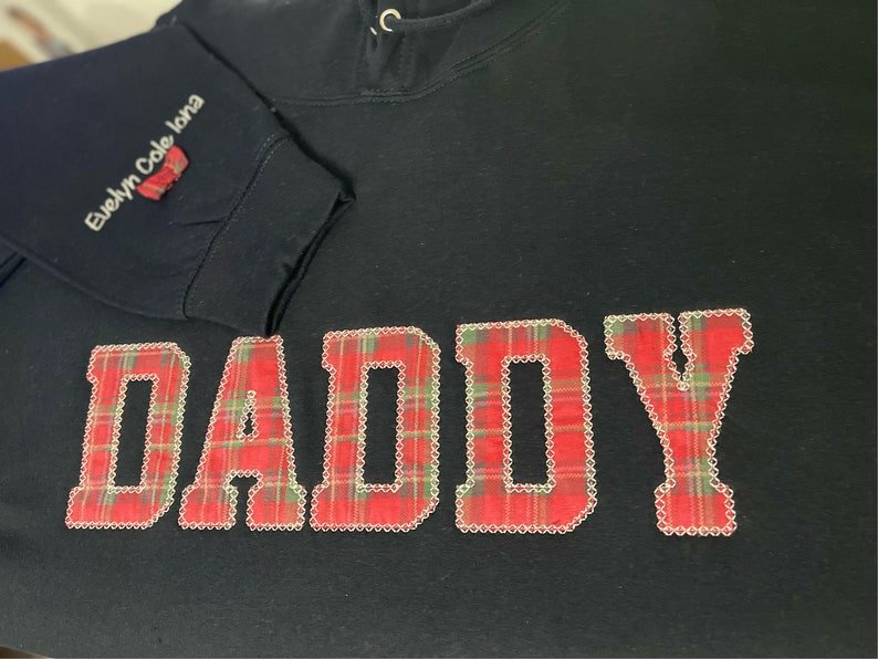 Black sweatshirt with appliqué “Daddy” in red check fabric design