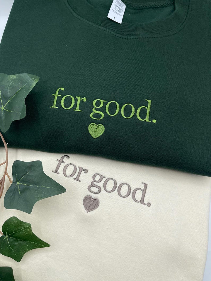 Green sweatshirt with “For Good.” Wicked-inspired embroidered text and heart