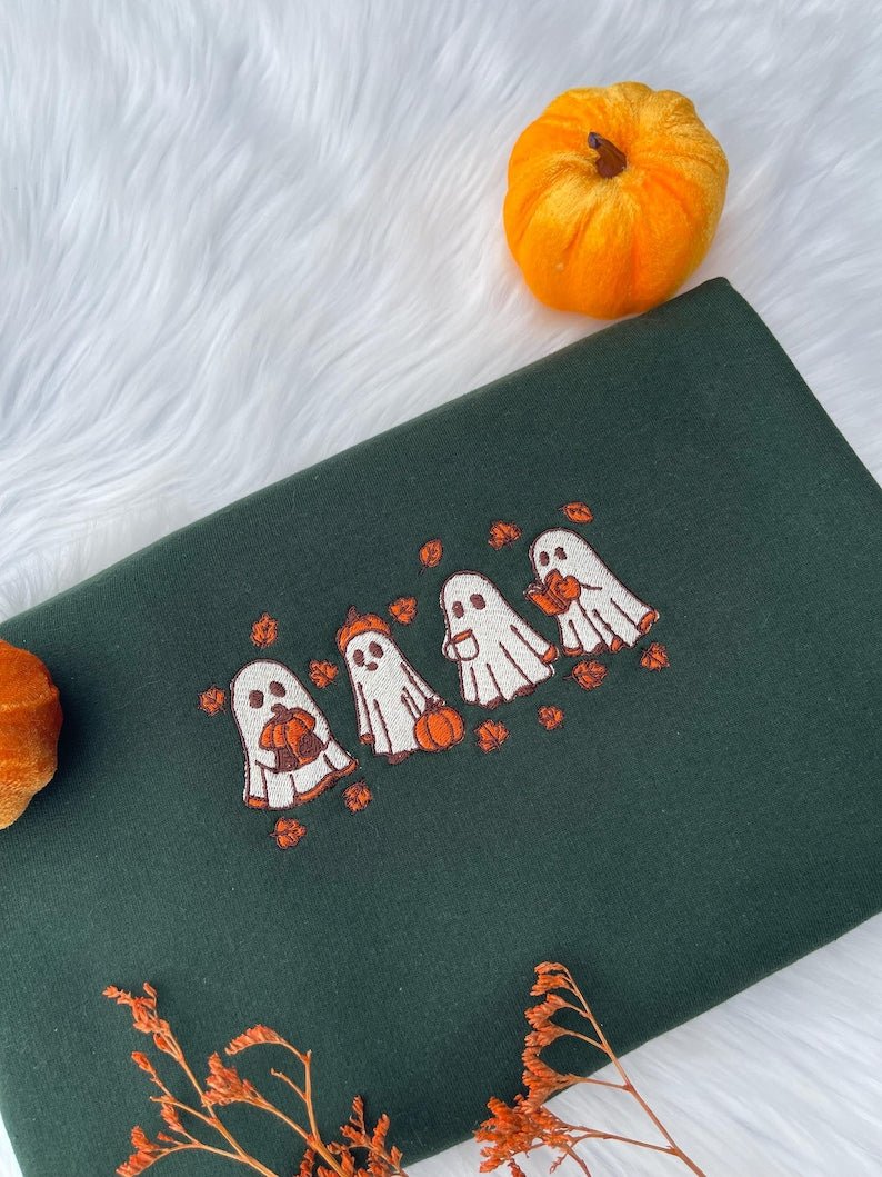 Green sweatshirt with embroidered line of Halloween ghosts holding pumpkins