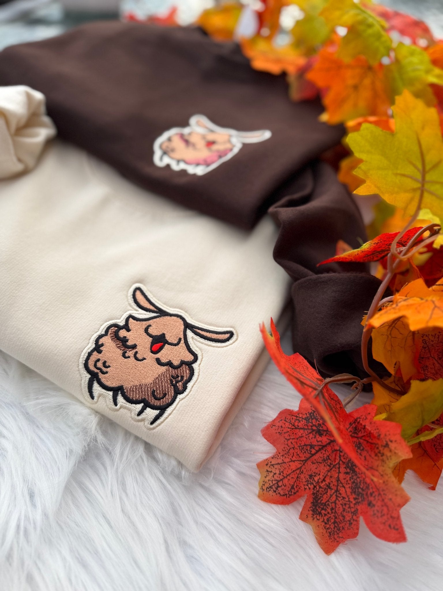 Milkshake and brown Silksong Flea embroidered sweatshirts styled with autumn leaves