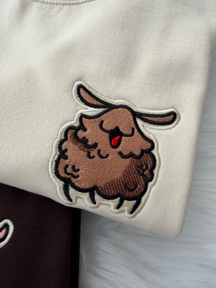 Close-up of embroidered Silksong Flea patch on Milkshake sweatshirt