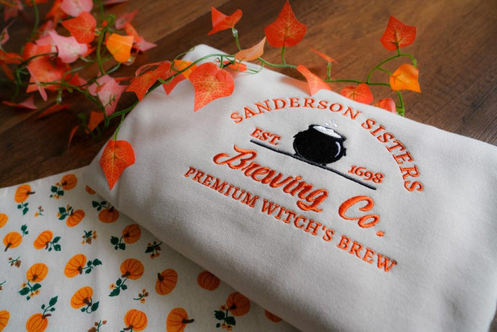 Sanderson Sisters Brewing Co embroidered sweatshirt in milkshake cream with orange design